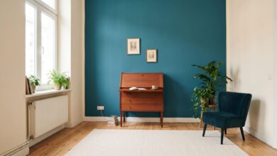 Welche Farbe passt zu Mahagoni? 6 Mahagoni-Sekretär vor einer Wand in Petrol mit Sessel in Blaugrün und hellem Dielenboden